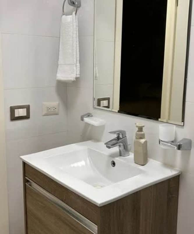 Modern bathroom with floating vanity, big mirror, wood-look tile PH Coco del Mar