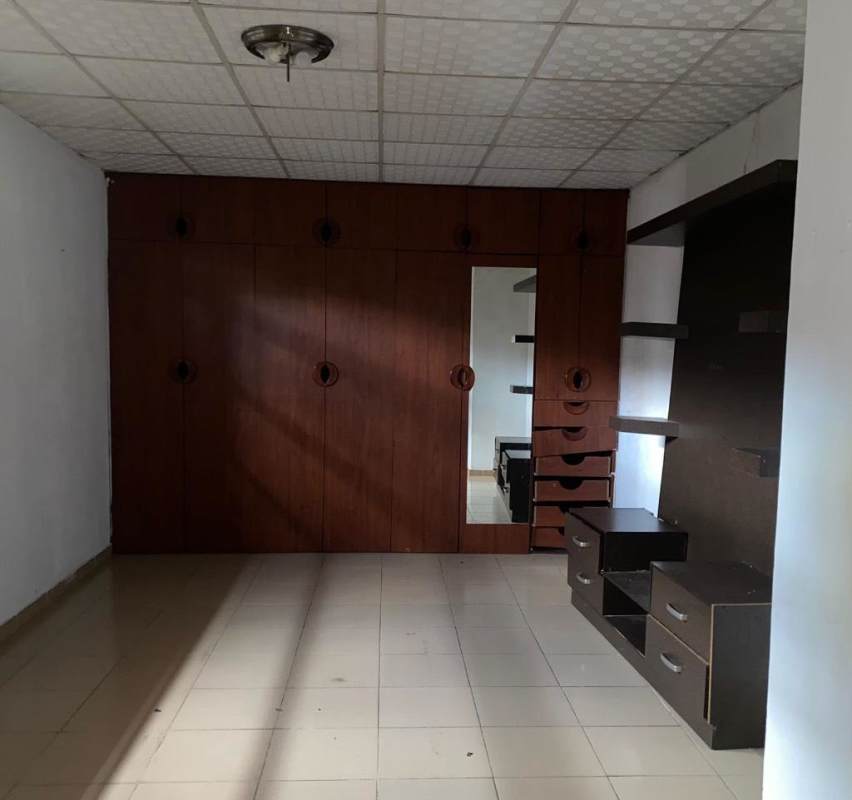 Bedroom with built-in wood wardrobes, mirror, white tiles in El Crisol rental house Panama