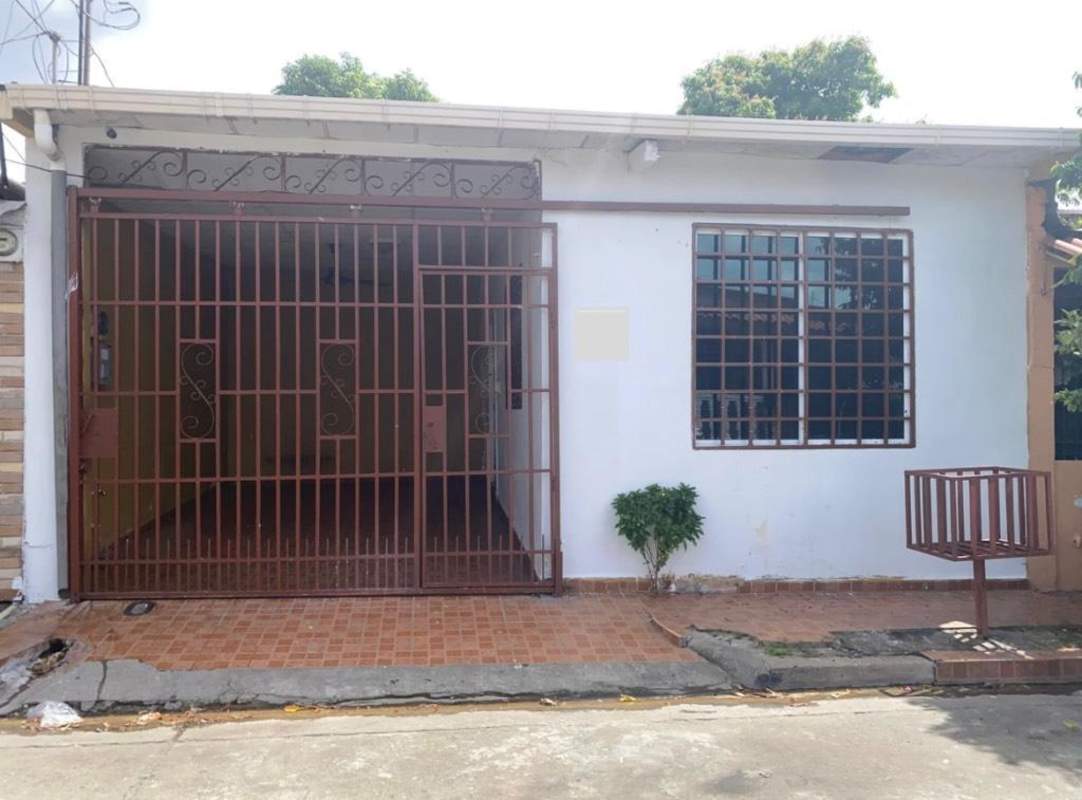 Exterior view of home for rent with metal security gate, tiled front porch and sidewalk Villa Lucre Panama