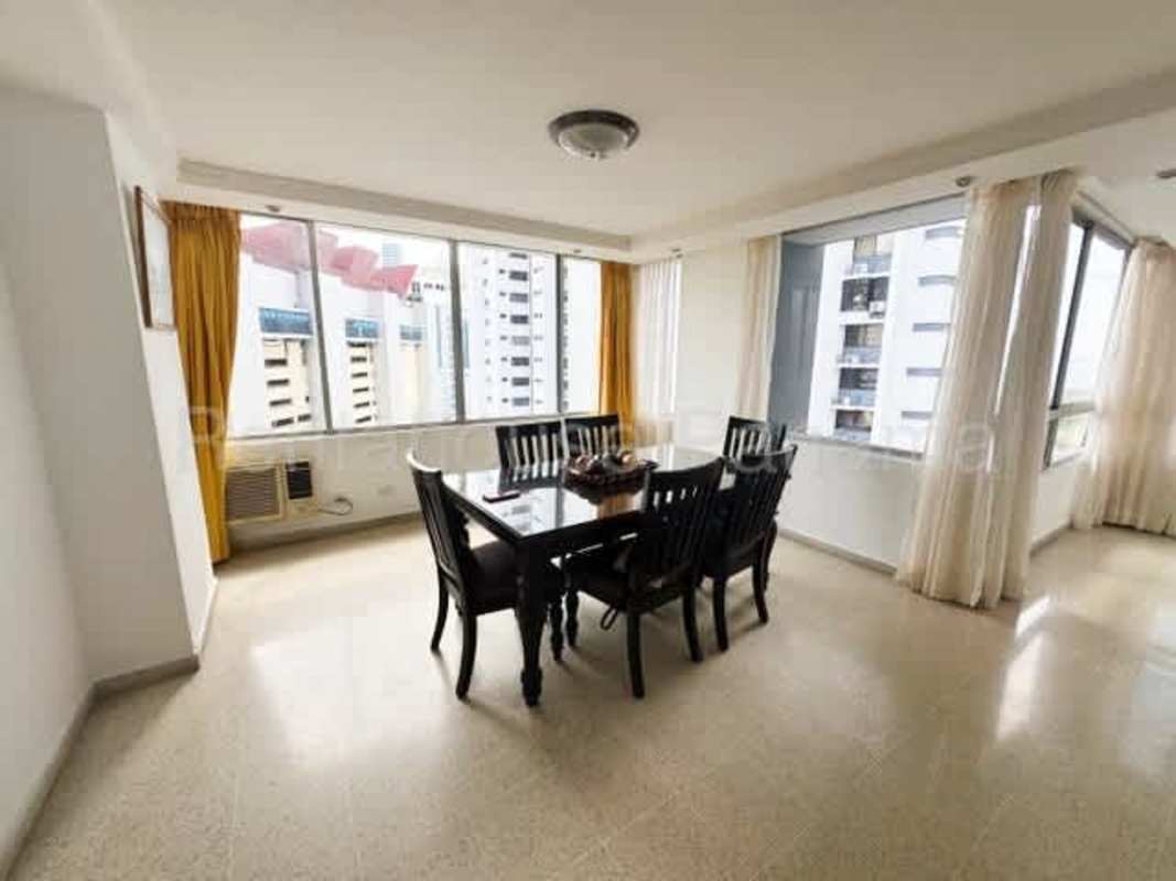 Dining room with city views, marble floors, and bright windows in PH Marina Plaza Marbella Panama