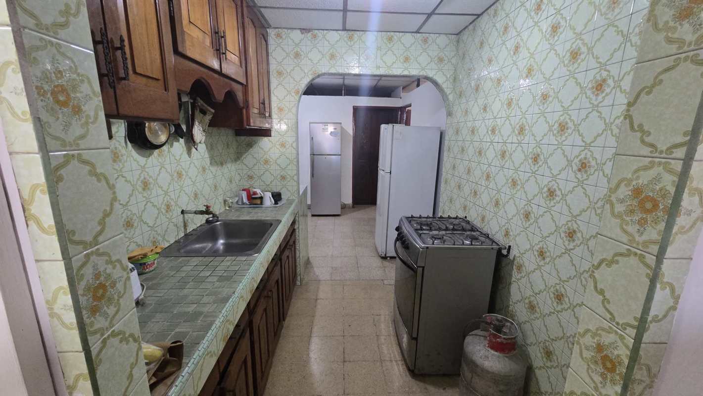 Traditional kitchen with green decorative tiles and wood cabinets Betania Panama