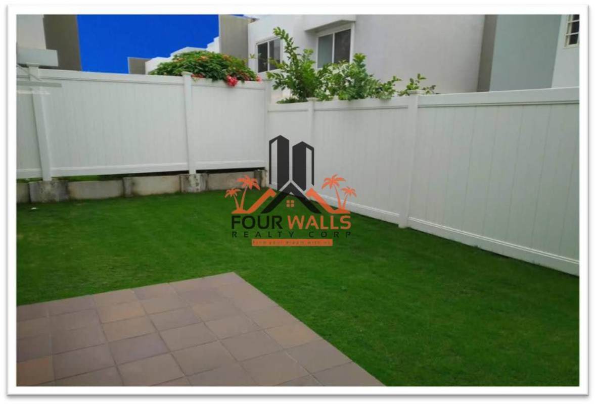 Fenced backyard with green lawn and neighboring buildings PH Augusta Panama