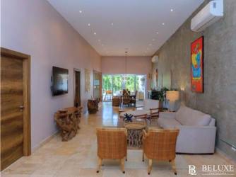 Spacious living room with high ceilings, neutral stone floor, tropical decor in Punta Barco beach villa Panama