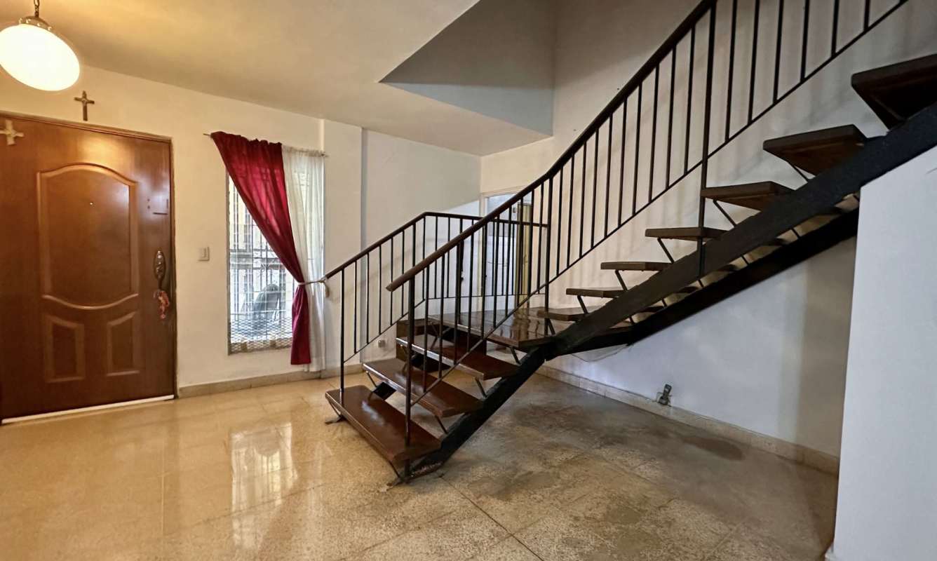 Entry hall with wooden door, metal floating stairs and windows Las Fuentes Panama