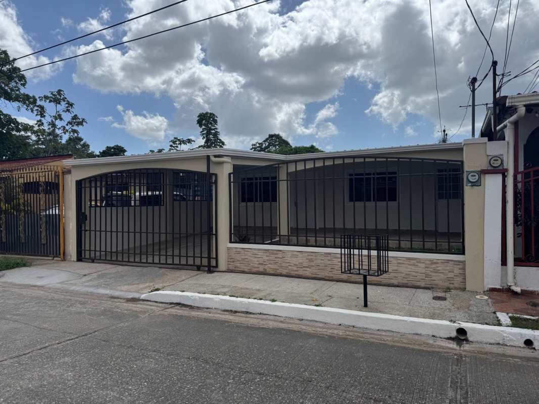 Full kitchen with white tile walls wood cabinets in Altos de las Praderas house Panama