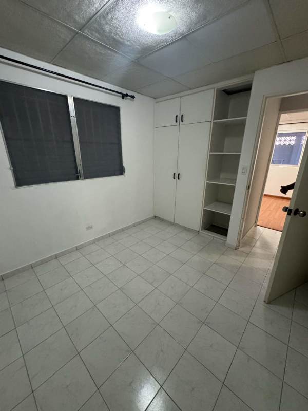 Covered two-car garage with manual gate and tiled driveway at Altos de las Praderas home