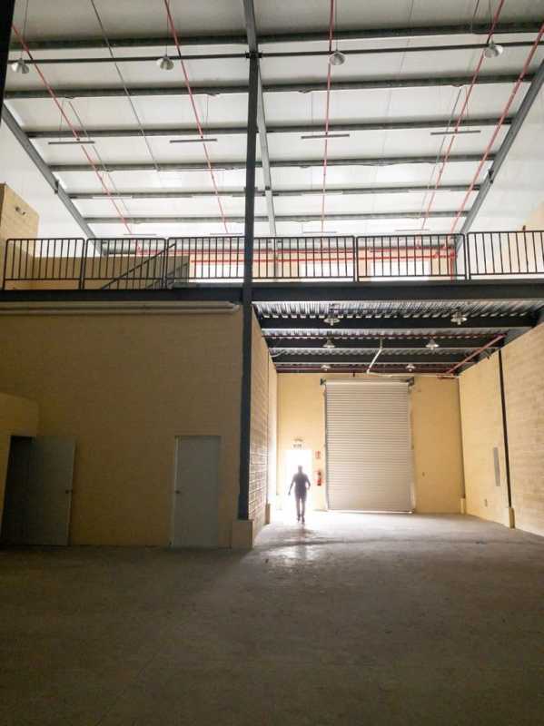 Wide open warehouse interior with high ceiling, mezzanine floor, roller doors Via Tocumen Panama