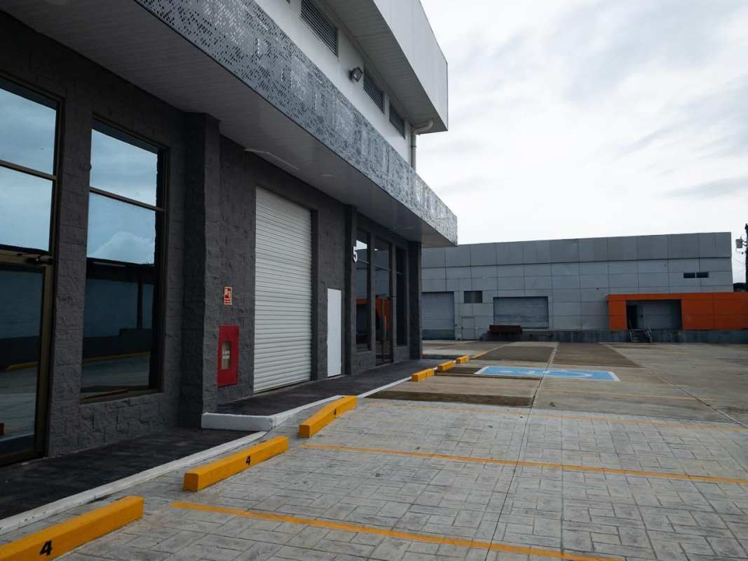 Exterior modern warehouse with large window, roll-up door, parking spaces Via Tocumen Panama
