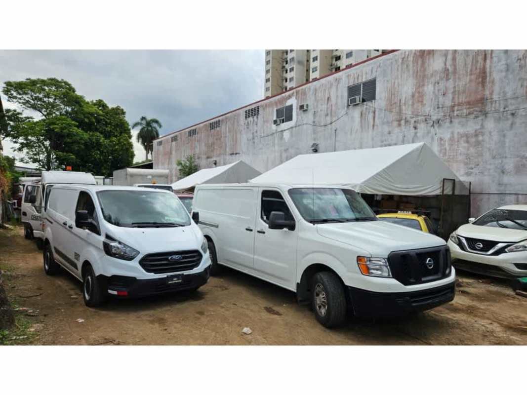 Commercial parking lot with vans, tent canopy and large building wall Parque Lefevre Panama