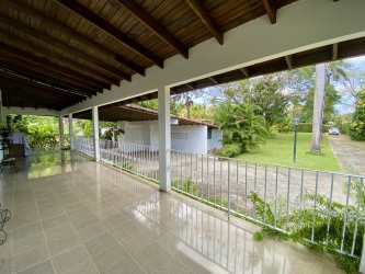 Covered outdoor porch area overlooking gardens in beachfront luxury estate Coronado Panama.