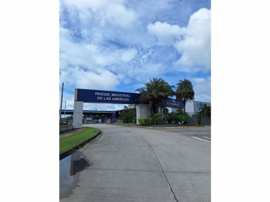 Facade of commercial warehouse with blue metal roof and large entrance gates at Parque Industrial Las Americas Pacora