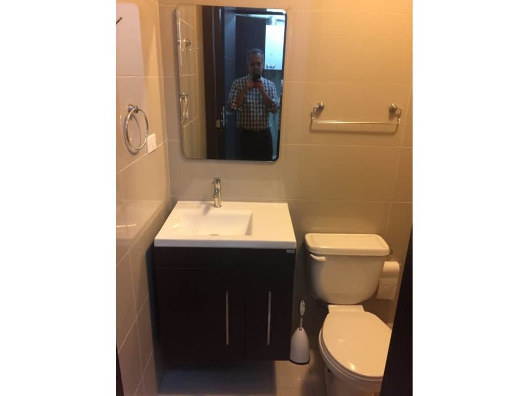 Modern bathroom with sink, toilet, and tiled walls at Grand Tower Punta Pacífica Panama