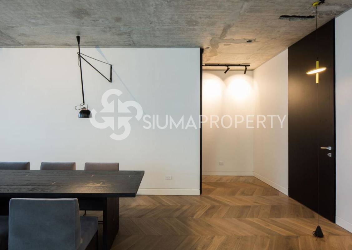 Industrial style dining area with concrete ceiling, herringbone wood floor at PH Coco del Mar penthouse Panama