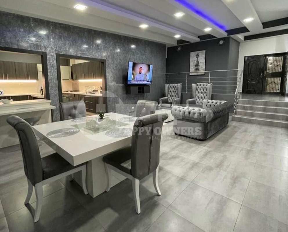 Contemporary open plan dining and living area featuring grey accents and marble wall at PH Vista Magna Panama