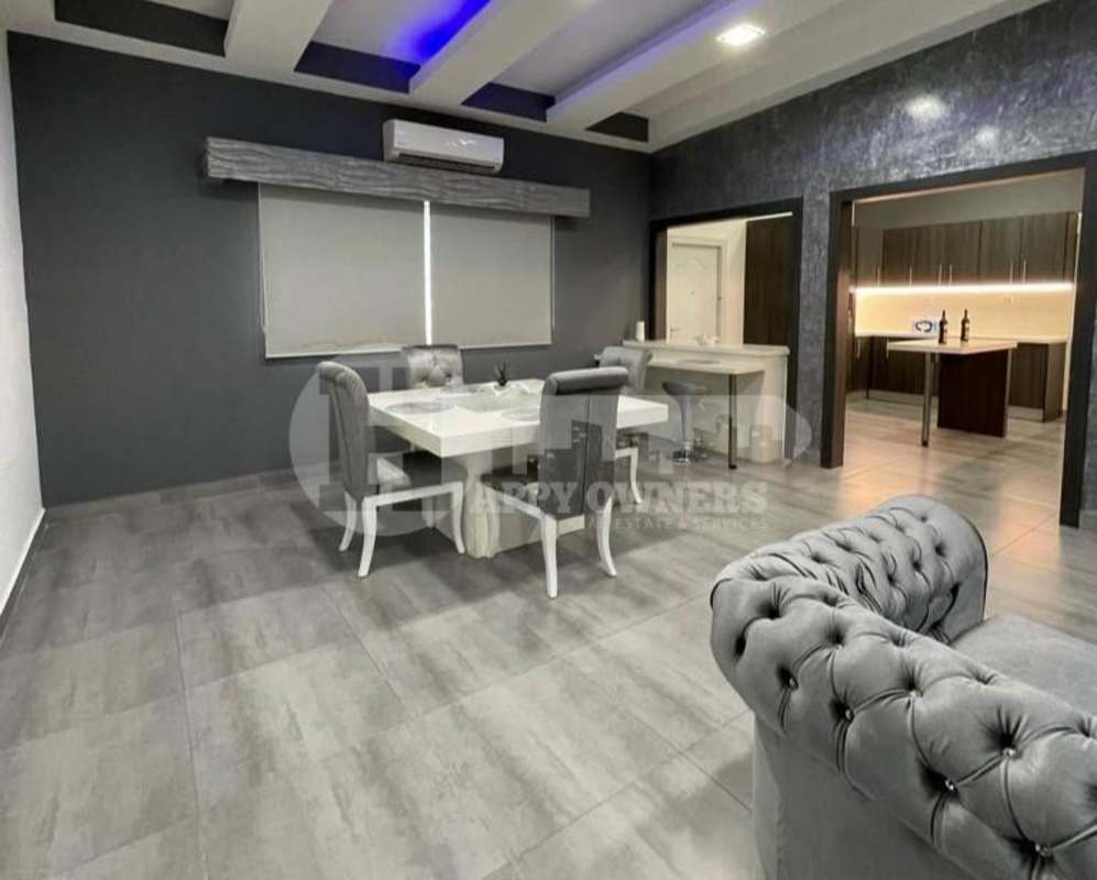 Modern dining space with view of open kitchen, island and dark cabinetry PH Vista Magna Altos de Panamá