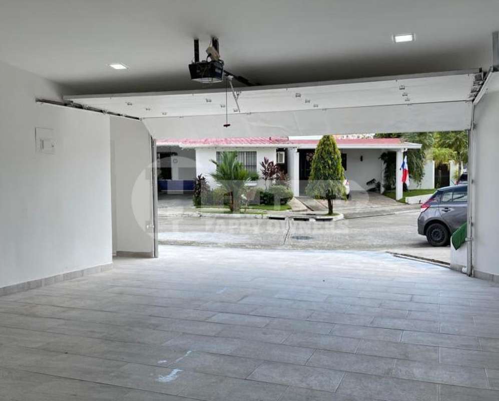 Clean attached garage interior with tiled floor and automatic door at PH Vista Magna Altos de Panamá