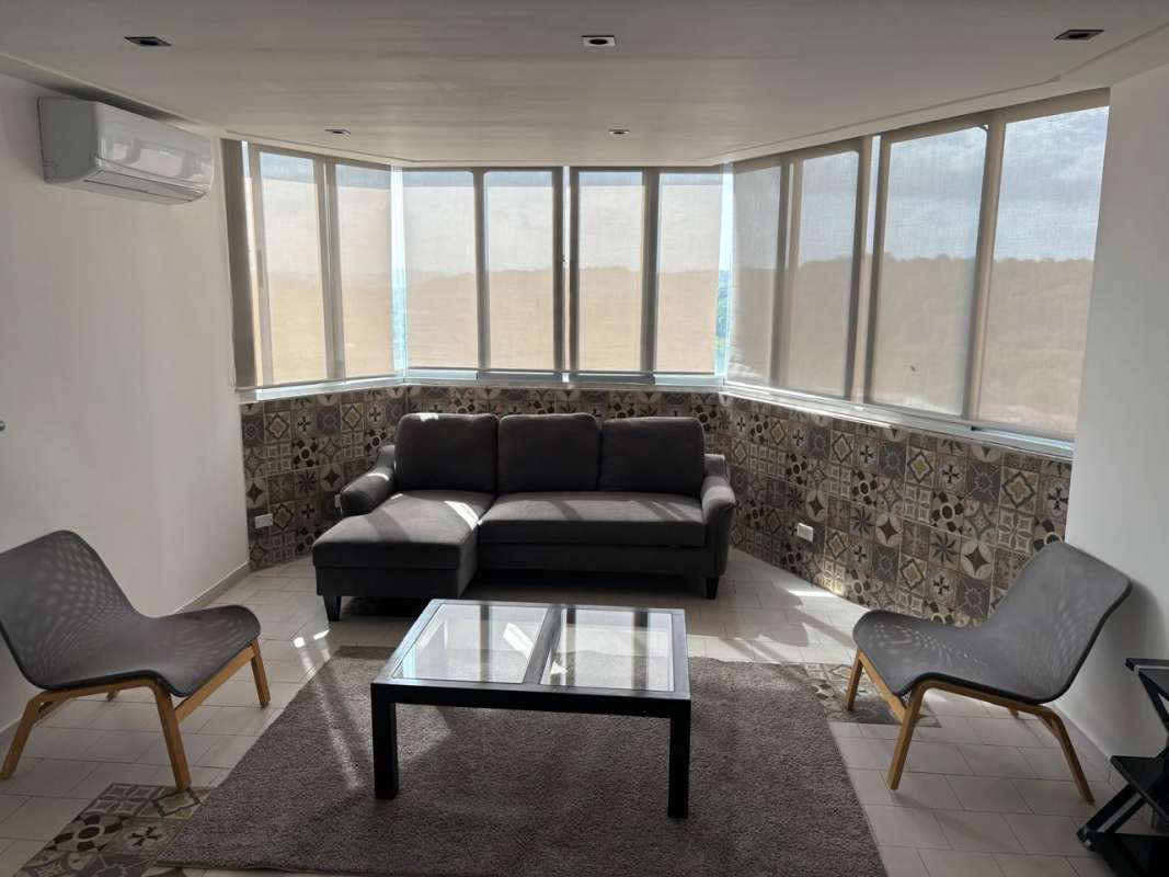 Living area with large windows sofa gray furniture and AC PH Las Terrazas Villa de las Fuentes Panama
