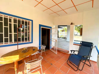 Cozy patio with terracotta floors, blue trims, outdoor chairs at country house Los Santos Panama