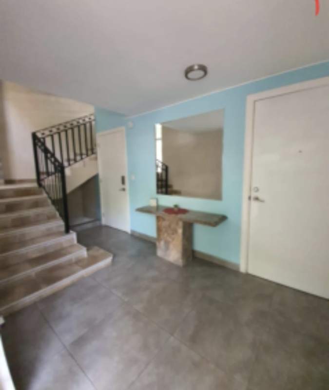 Modern entryway with blue accent wall mirror and staircase in Balboa Ancón studio apartment