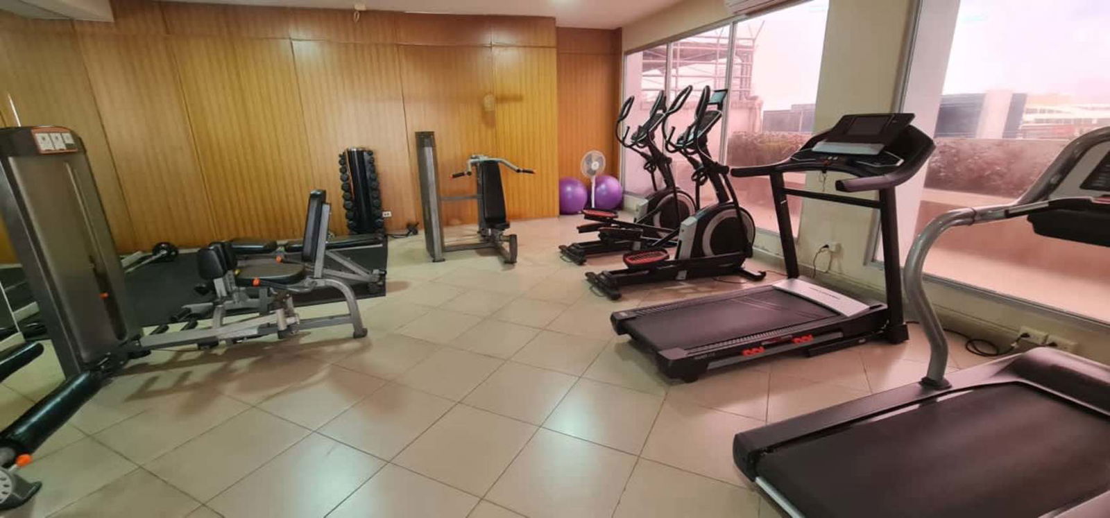 Apartment balcony with glass railing and skyline urban views in PH Metric