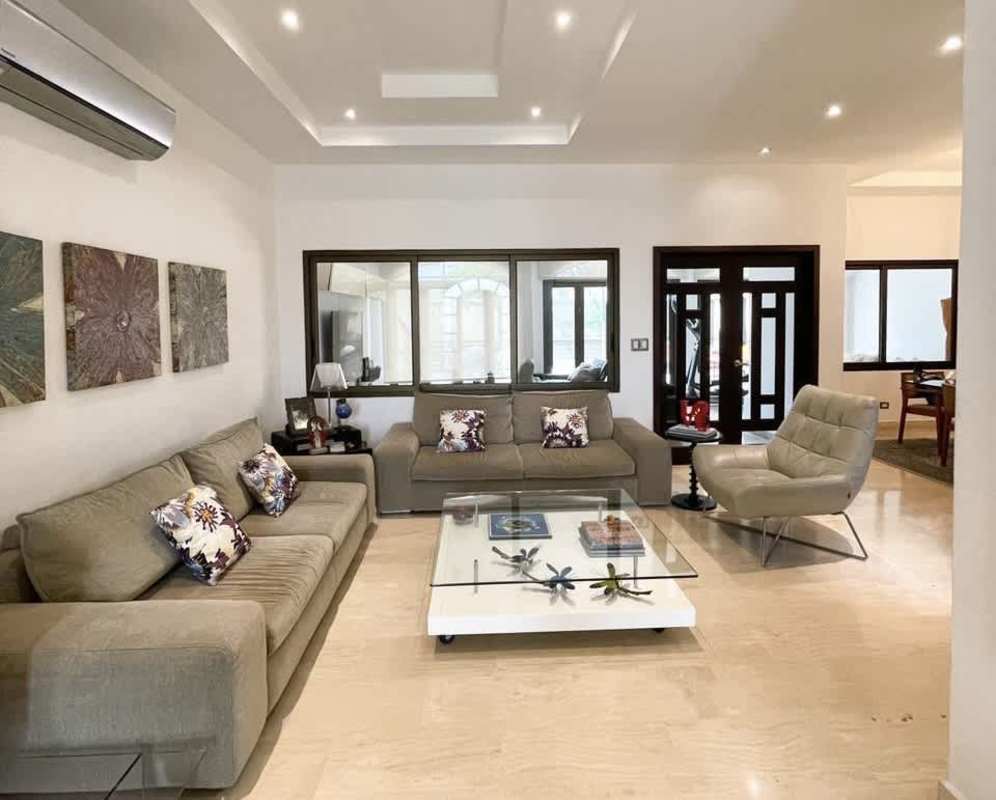 Contemporary living room beige sofas, tile floors, AC in luxury Costa Sur residence Panama City