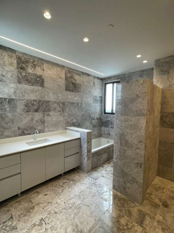Modern bathroom with marble walls, bathtub, floating vanity in PH Empire Residences Santa Maria Panama
