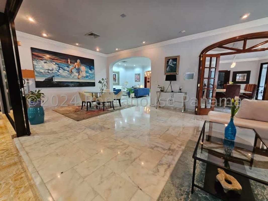 Spacious open-plan living room with marble floors, glass ceiling, and bar area in luxury home Altos del Golf Panama