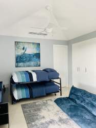 Bright bedroom with large windows and lagoon views in Laguna Buenaventura penthouse Panama