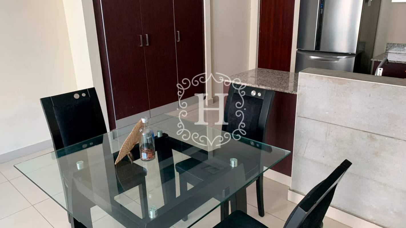 Dining area with glass table adjacent to granite kitchen in Vitro Loft El Cangrejo