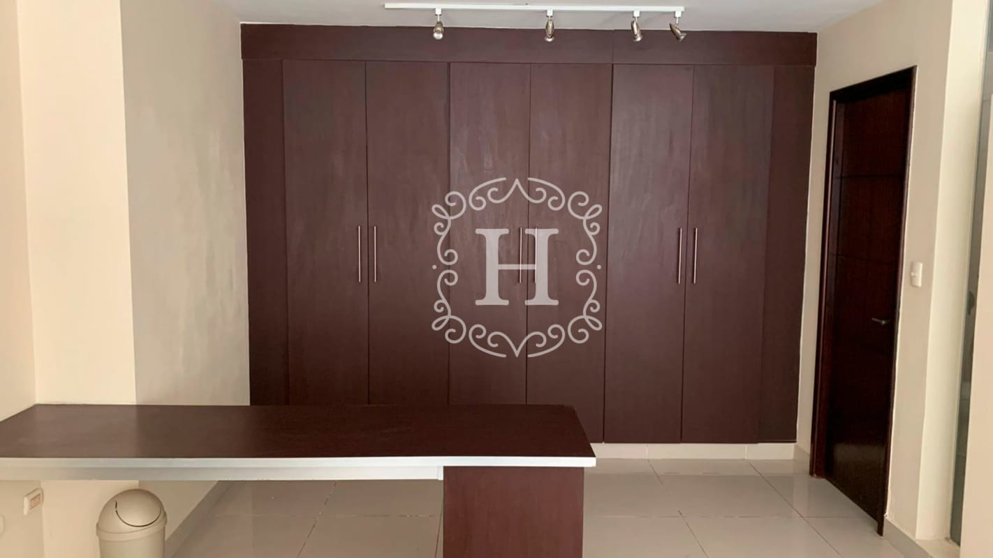 Spacious walk-in closet with dark wood cabinetry in PH Vitro Loft Panama