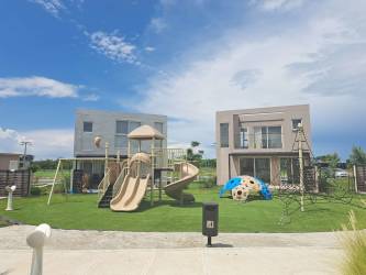 Outdoor pool surrounded by villas and palm trees in Punta Chame Beach Residences