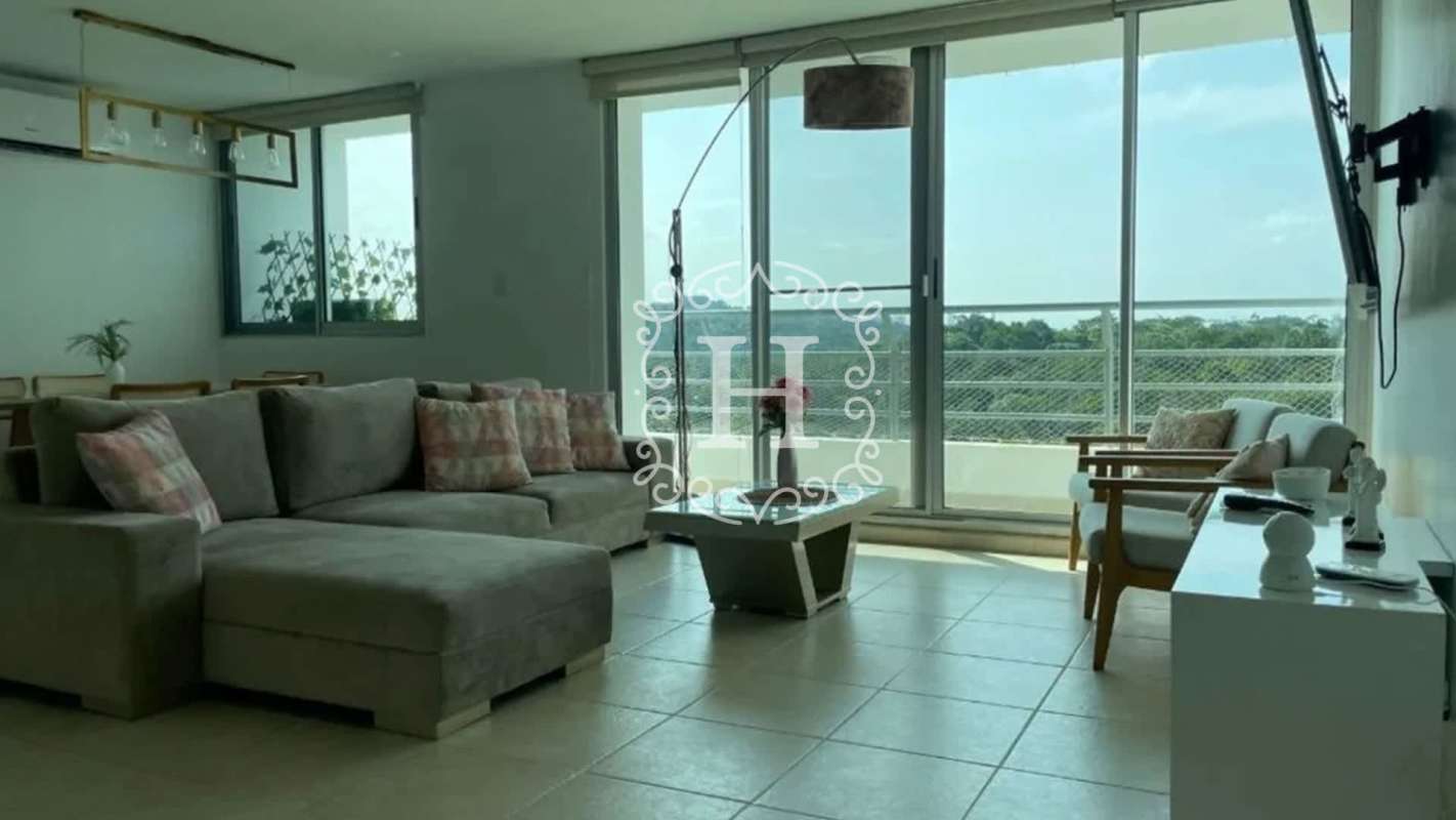 Contemporary living-dining area with large sliding doors to balcony and nature views at PH Clayton Park I Panama City