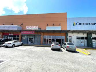 Exterior view of commercial retail unit with large glass entrance and ample parking at Plaza 4 Altos Colon Panama