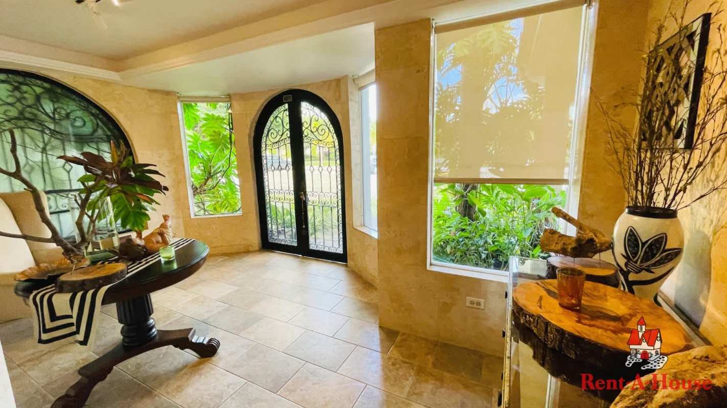 Grand entryway with iron doors, wood furniture, natural light in Costa Bella Panama