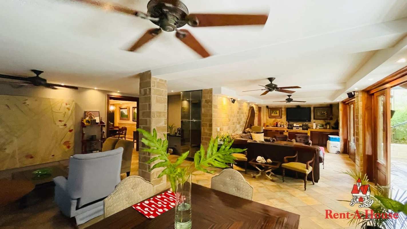 Spacious kitchen with wood cabinetry, granite counters, island in Costa del Este Panama