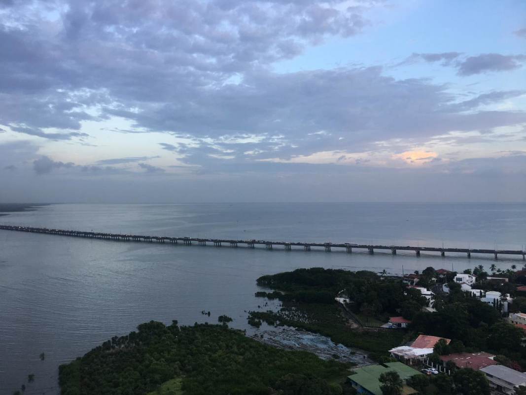 Spacious living room with marble flooring, panoramic glass windows and balcony overlooking the marine skyline in PH Riviera del Mar Panama
