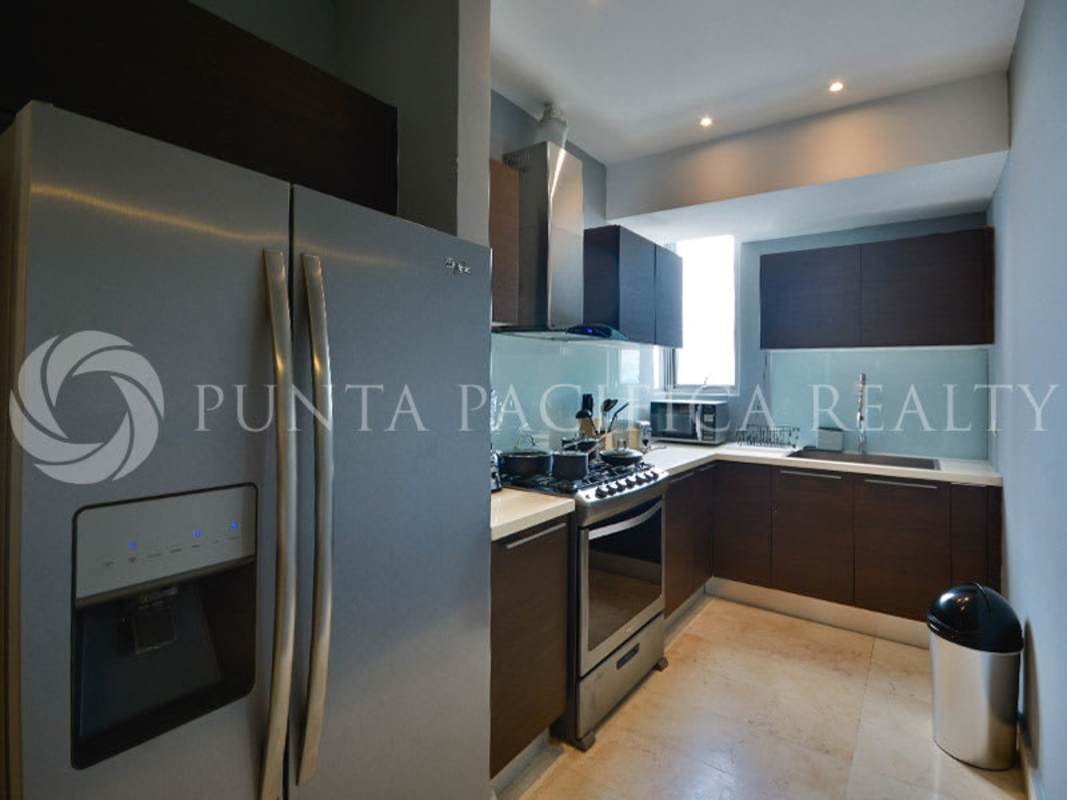 Sleek bathroom with marble tiles and glass shower Yoo Panama Punta Paitilla apartment