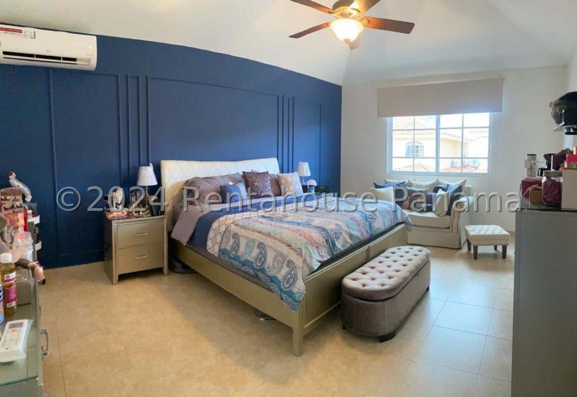 Master bedroom with navy accent wall, upholstered bed Costa del Este Panama City