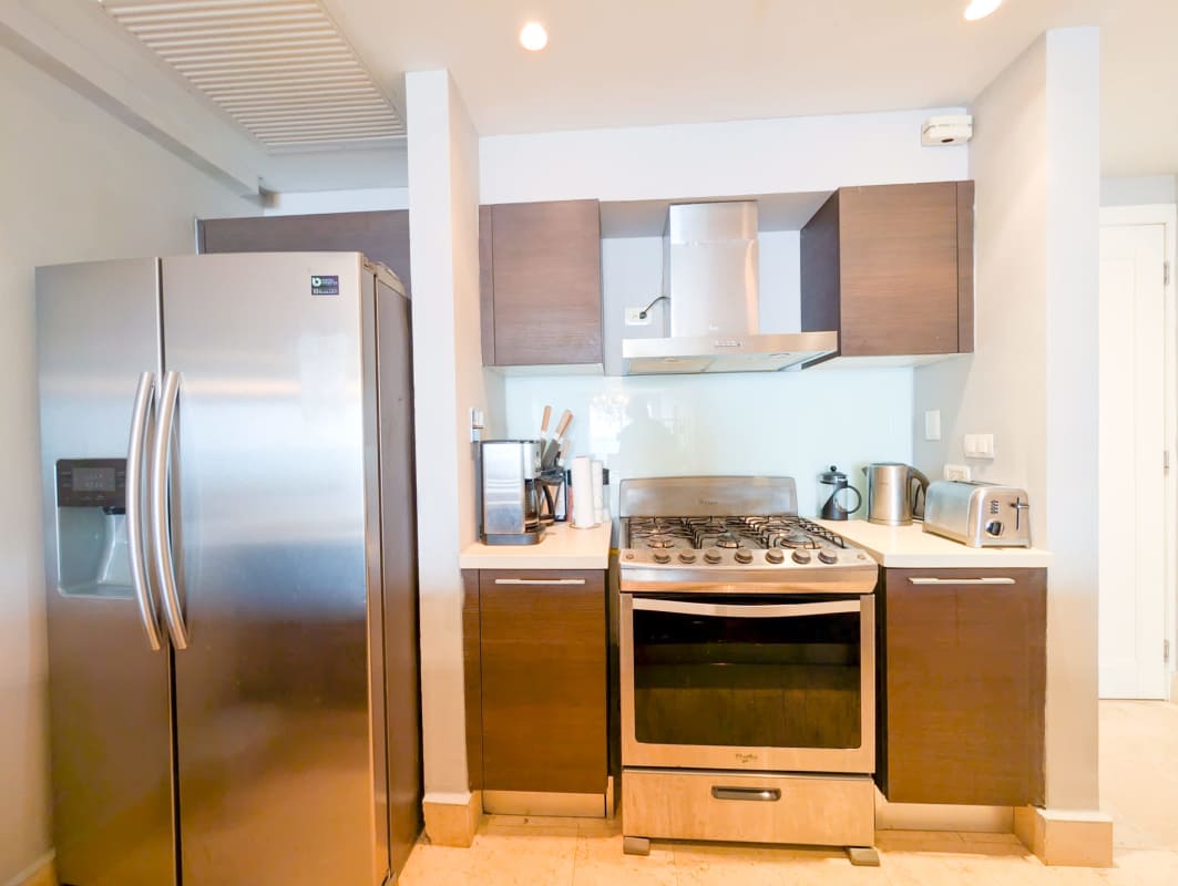 Modern open kitchen with stainless appliances and cabinetry in Yoo Panama apartment Avenida Balboa