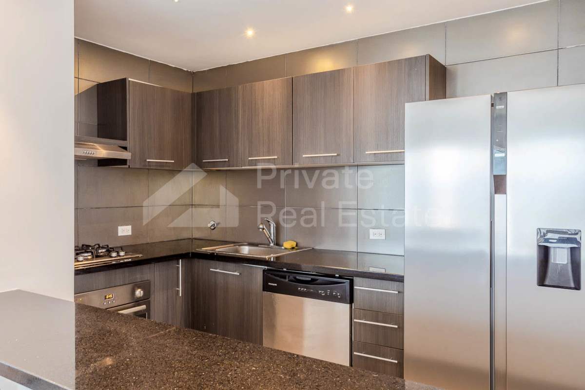 Open concept kitchen with granite countertops and stainless appliances at PH Yacht Club Avenida Balboa Panama