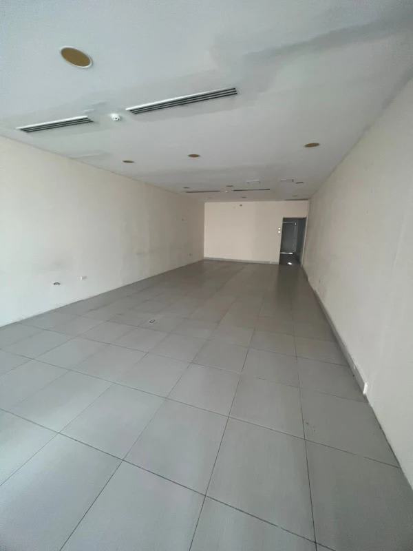 Open plan empty commercial unit with tile floors, neutral walls and ceiling lights for lease in Coco del Mar San Francisco Panama