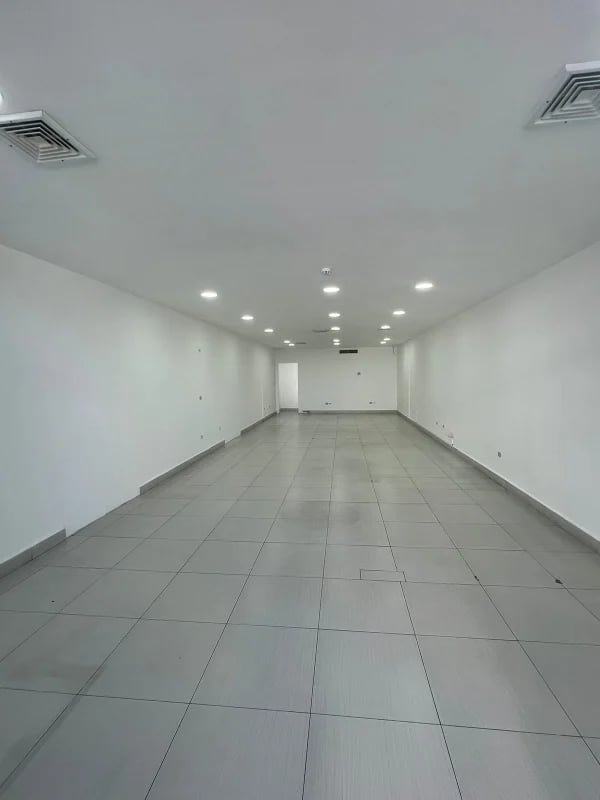 Large empty commercial retail or office interior with white walls, tiled flooring, recessed lighting at Plaza Coco del Mar Panama