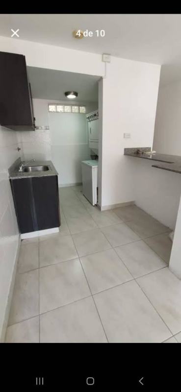 Modern kitchen with white walls, tile floors, and cabinets Condado del Rey