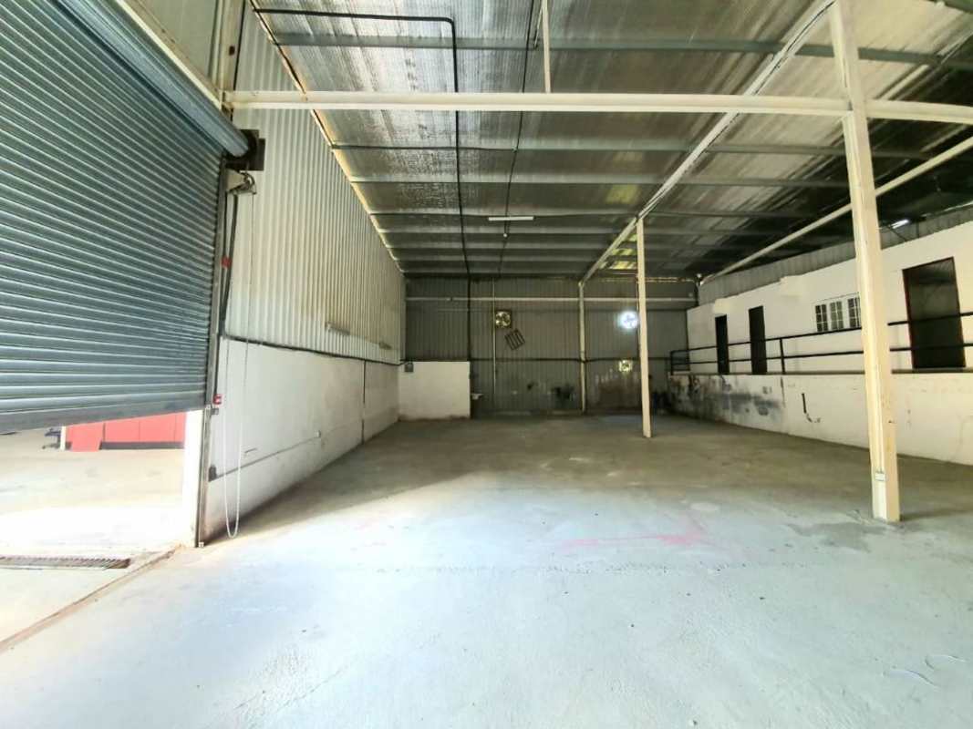 Empty warehouse interior with large shutter door concrete floor Panama