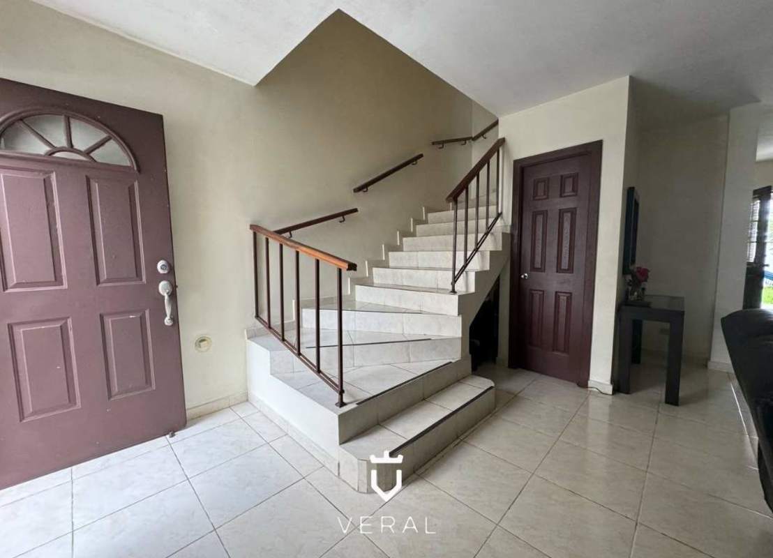 Large covered terrace with ceramic tiles and hammock overlooking green backyard in Panama Norte house