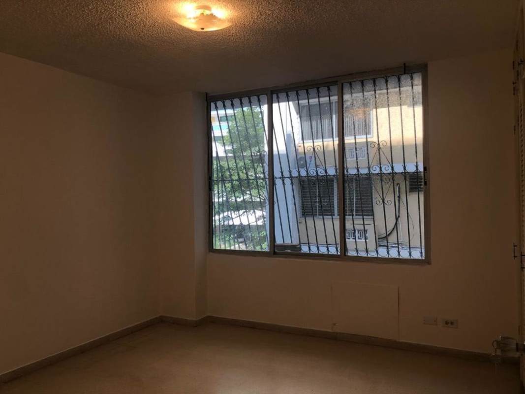 Living room with window security bars and ceiling light in PH Punta Paitilla Panama rental unit