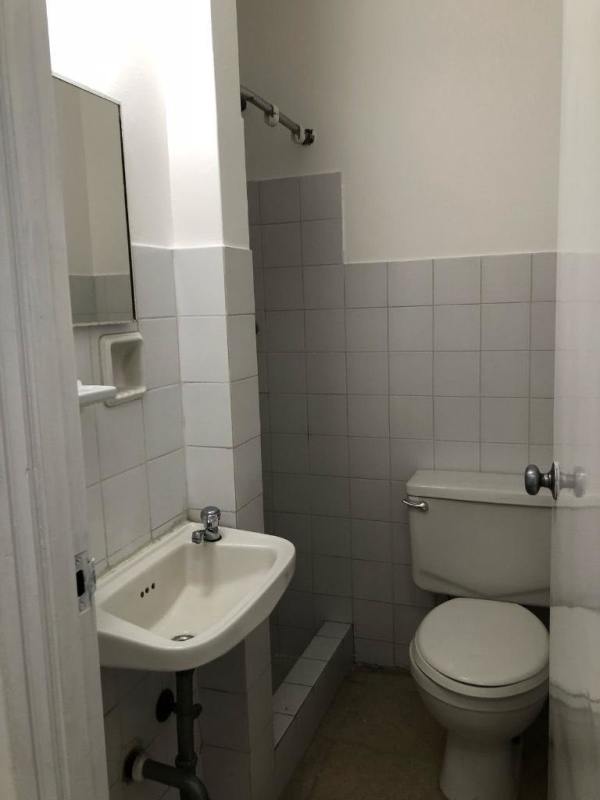 Compact bathroom with tile walls, shower, and vanity in PH Punta Paitilla rental apartment