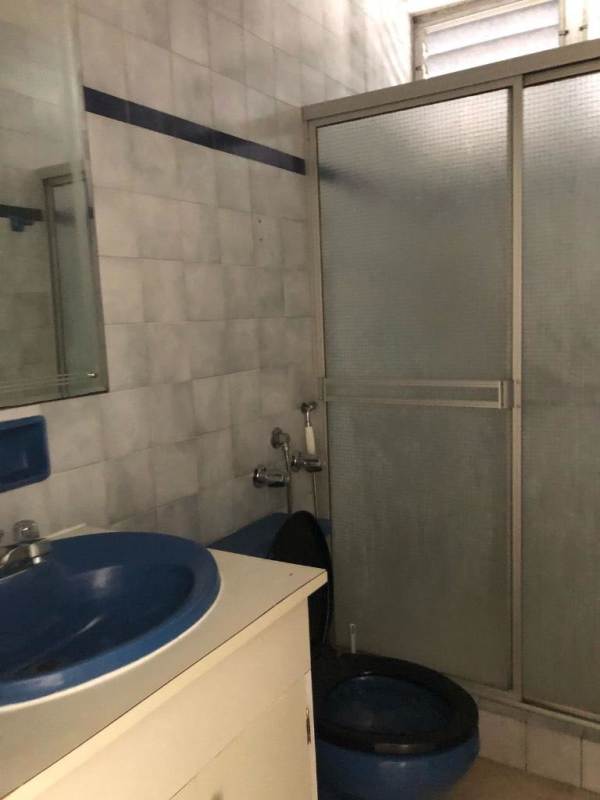 Blue sink and toilet bathroom with shower enclosure in PH Punta Paitilla apartment Panama