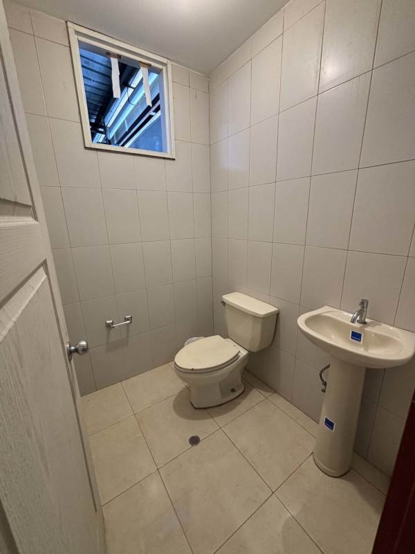Small tiled business bathroom with sink, toilet and window Ciudad Radial Panama