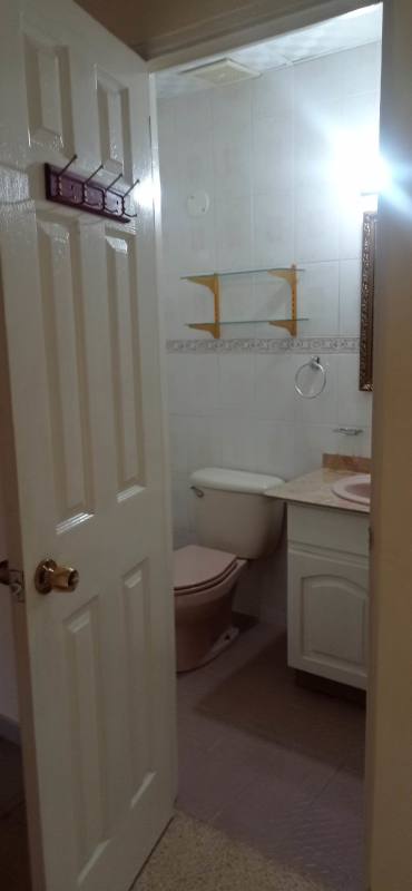 Tiled bathroom with vanity and hooks on door Villa Flor Panama City